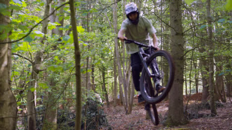 Slow-Motion-Shot-Of-Man-On-Mountain-Bike-Making-Mid-Air-Jump-On-Dirt-Trail-Through-Woodland-7