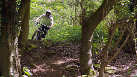 Toma-En-Cámara-Lenta-Del-Hombre-En-Bicicleta-De-Montaña-Haciendo-Salto-En-El-Aire-En-Un-Sendero-De-Tierra-A-Través-Del-Bosque-10