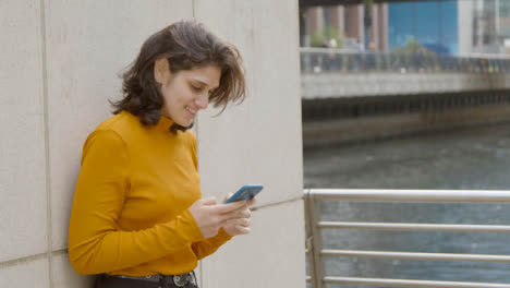 Handheld-Shot-of-Young-Woman-Texting-On-Her-Mobile-Phone