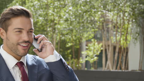 Businessman-Outside-Office-Taking-Call-On-Mobile-Phone