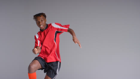 Young-Male-Footballer-In-Studio-Running-and-Heading-Ball-3
