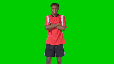 Studioporträt-Eines-Jungen-Männlichen-Fußballers-Mit-Vereinsausrüstung-Vor-Grünem-Bildschirm-1