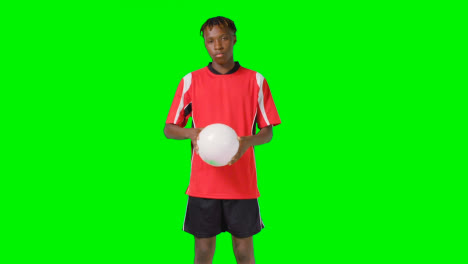 Studio-Portrait-Of-Male-Footballer-Wearing-Club-Kit-With-Ball-Under-Arm-Against-Green-Screen-1