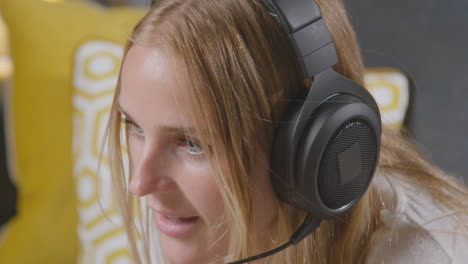 Frau-Mit-Headset-Sitzt-Zu-Hause-Auf-Dem-Sofa-Und-Spielt-Online
