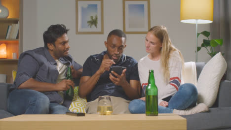 Multi-Cultural-Friends-Ordering-Takeaway-Food-Delivery-On-Mobile-Phone-Sitting-On-Sofa-At-Home-Together-7