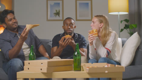 Multikulturelle-Freunde,-Die-Zu-Hause-Auf-Dem-Sofa-Sitzen,-Pizza-Zum-Mitnehmen-Essen-Und-Bier-Trinken-3