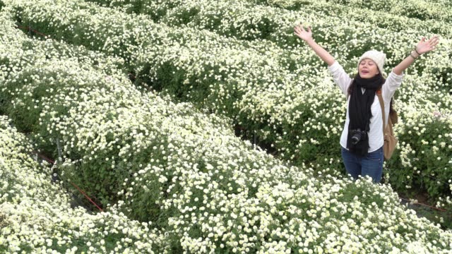 Carefree-asian-in-the-daisies-field-in-autumn