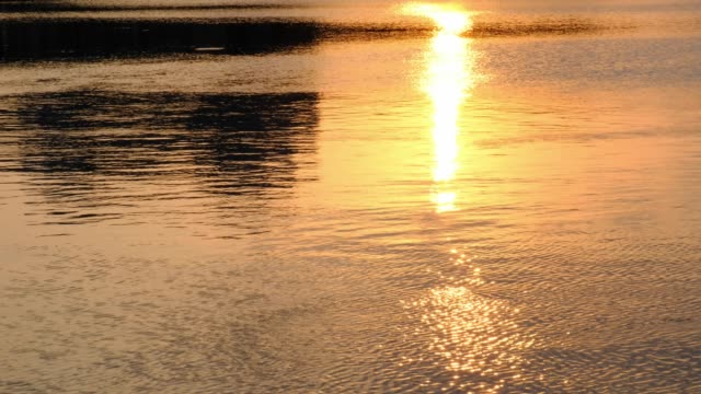 Sunset-golden-Reflexion-des-Sonnenlichts-im-Wasser,-Sonnenuntergang-über-Wellen-Fluss