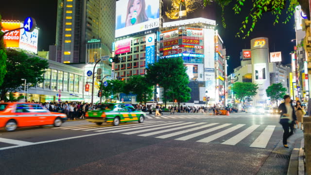 Stadtteil-Shibuya-in-der-Nacht-mit-Publikum-vorbeigehen-Zebrastreifen.-Tokio,-Japan.-4K-Zeitraffer