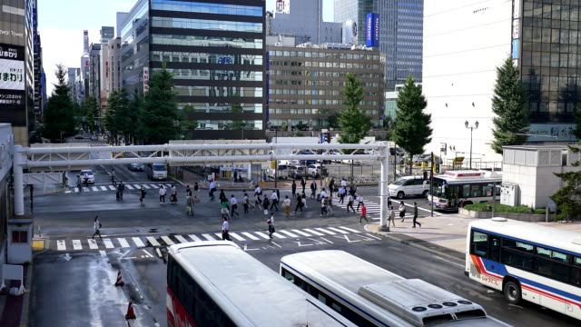 Wide-shot-of-people-walking-at-a-busy-cross-road-junction