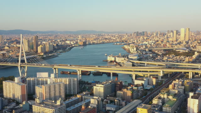 Aerial-view-over-Osaka-port-and-Tempozan-Giant-ferris-wheel,-Hanshin-Expressway,-Aji-river-and-Yodo-river-with-Osaka-city-in-background.
