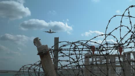 4K,CU-Shot-of-barbed-wire-and-airplane.