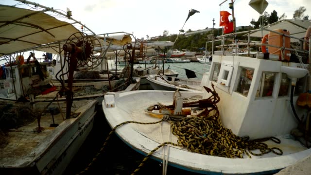 Barcos-en-una-bahía-de-pesca-en-el-interior-de-las-banderas-turco,-cerca-de-mar-Mediterráneo-en-el-viento