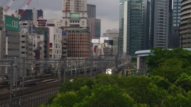 Shinkansen-high-speed-bullet-train-arriving-downtown-Tokyo-city