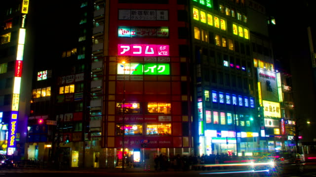 Lapso-de-la-noche-con-neones-japonés-en-Shinjuku-lado-sur-amplia-disparo-panorámica-izquierda