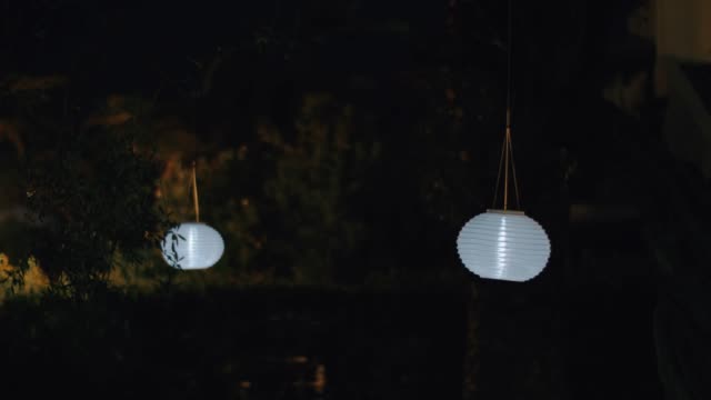 Round-white-paper-lanterns-in-night-garden