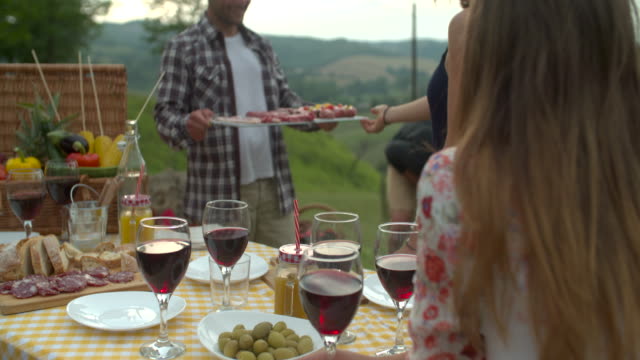 Group-of-friends-doing-a-bbq-in-the-countryside-together.-shot-in-slow-motion