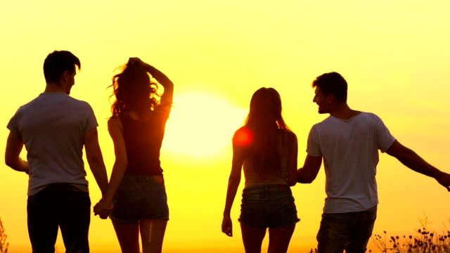 The-four-people-jumping-on-the-bright-sun-background.-slow-motion