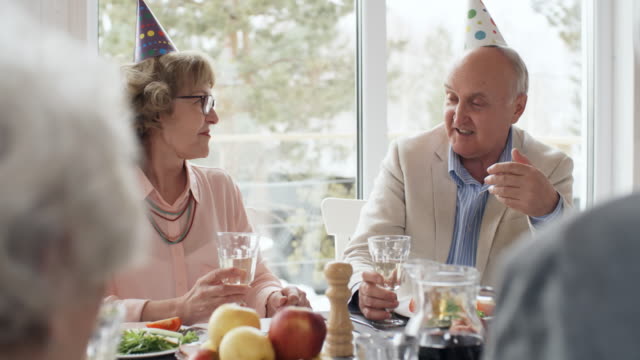 Senior-hombre-hablando-con-la-amiga-en-la-fiesta-de-cumpleaños
