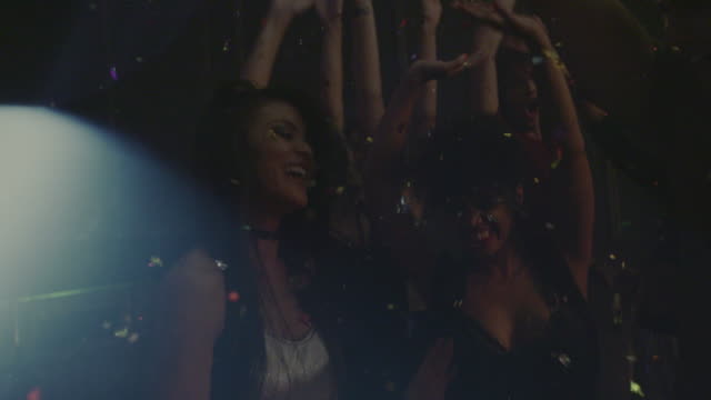 Group-of-friends-dancing-at-nightclub-with-confetti