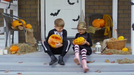 Kinder-in-Halloween-Kostümen-spielen-mit-Jack-o-Laternen