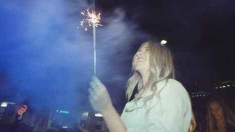 Young-hipster-girl-friends-having-fun-running-with-sparklers-and-smoke-grenade-and-night-with-shopping-cart