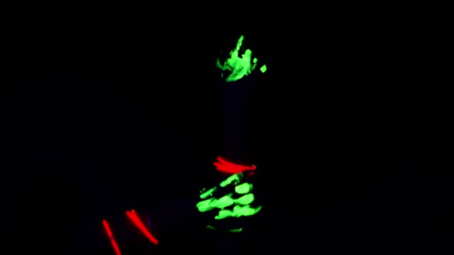 Glowing-hand-dancing-movement-in-black-background,-green-glowing-paint.-Women.