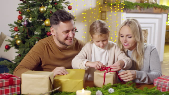 Kleines-Mädchen-Weihnachtsgeschenke-mit-Eltern-vorbereiten