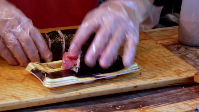 Nahaufnahme-eines-Küchenchefs-serviert-Sushi-am-Tsukiji-Fischmarkt