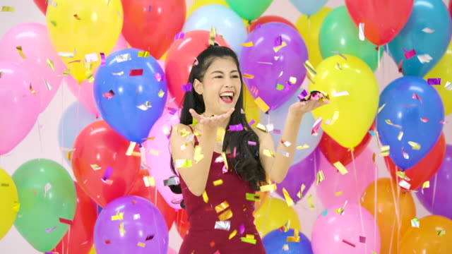 Schöne-asiatische-Frau-tanzen-glücklich-Rührung-mit-bunten-Ballon-Hintergrund-auf-der-Party-in-Zeitlupe.