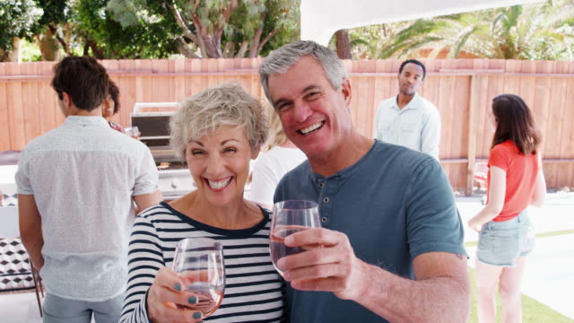 Älteres-Paar-auf-einer-Garten-Party-Brille-Kamera-erhöhen