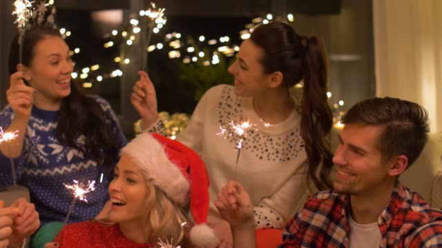 happy-friends-with-sparklers-celebrating-christmas-at-home-party