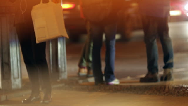 Anonyme-Menschen-warten-auf-die-Straße-zu-überqueren,-während-städtische-Atmosphäre-der-Stadt-bei-Nacht