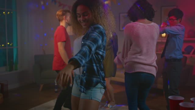 Auf-die-wilde-Hausparty:-schönes-schwarze-Mädchen-tanzt-verführerisch-in-Neonlicht.-Im-Hintergrund-andere-Leute,-die-Spaß,-Clubbing.