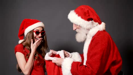 Santa-verleiht-Girl-Taschen-mit-Geschenken.