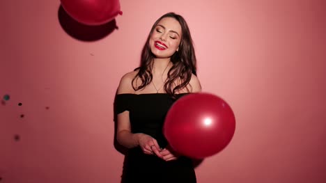 Brunette-happy-woman-laughing-with-confetti-in-pink-background-wear-red-dress