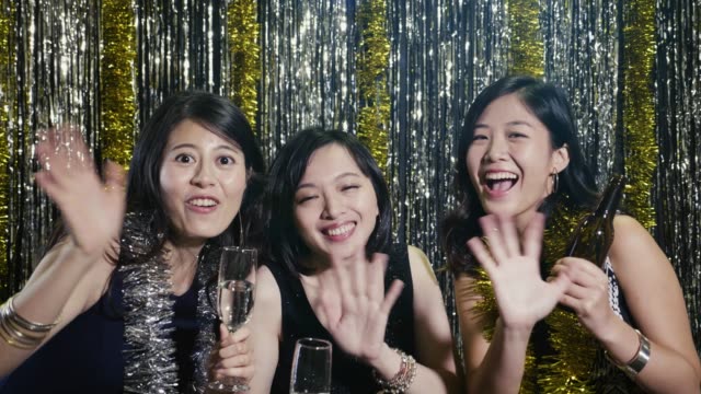 las-mujeres-asiáticas-enfrentan-las-manos-agitando-cámara-alegremente