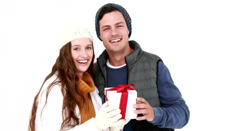 Casual-couple-in-warm-clothing-holding-gift