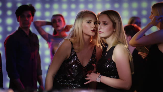Zwei-blonde-Mädchen-sprechen-auf-der-Tanzfläche-im-Verein