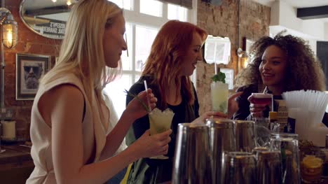 Female-Friends-Enjoying-Drink-In-Cocktail-Bar-Shot-On-R3D