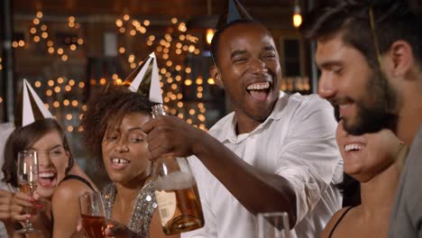Amigos-en-sombreros-del-partido-celebrando-año-nuevo-en-fiesta-en-un-bar