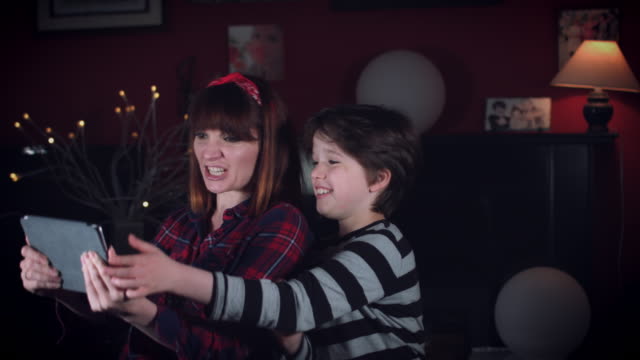 4-k-Einfamilienhaus-Schuss-des-Kindes-mit-Mama-mit-Spaß-spielen-auf-Tablet-Videospiel