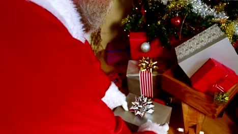Colocación-caja-de-regalo-Papá-Noel-cerca-de-árbol-de-Navidad