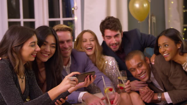 Friends-Posing-For-Photo-As-They-Celebrate-At-Party-Together