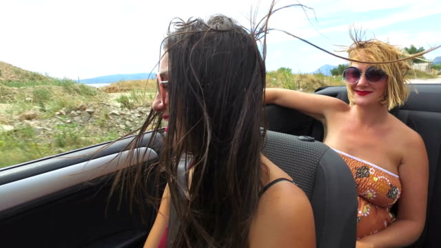 Zwei-attraktive-Frauen-Reiten-im-Cabriolet-entlang-der-dalmatinischen-Küste