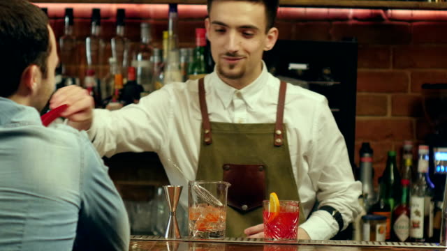 Barman-preparing-cocktail-for-a-client-and-waiting-for-his-reaction