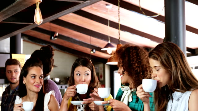 Grupo-de-amigos-interactuando-al-mismo-tiempo-que-café