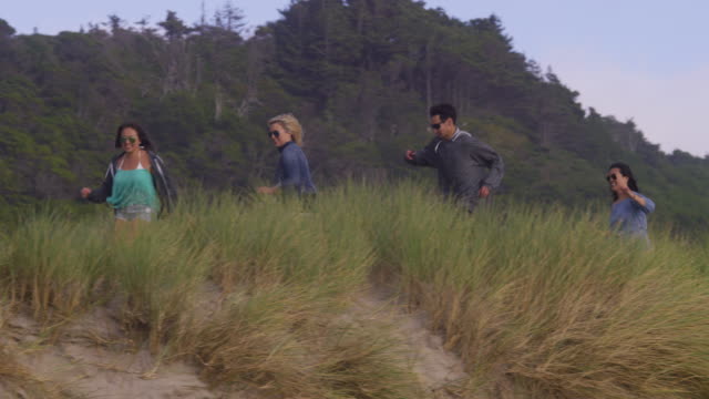 Friends-at-beach-running-down-grassy-trail