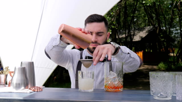 Barkeeper-Gießen-langsam-Likör-in-vorbereiteten-Weinglas-bar-Arbeiter-durch-Filter-cocktail-Zubereitung