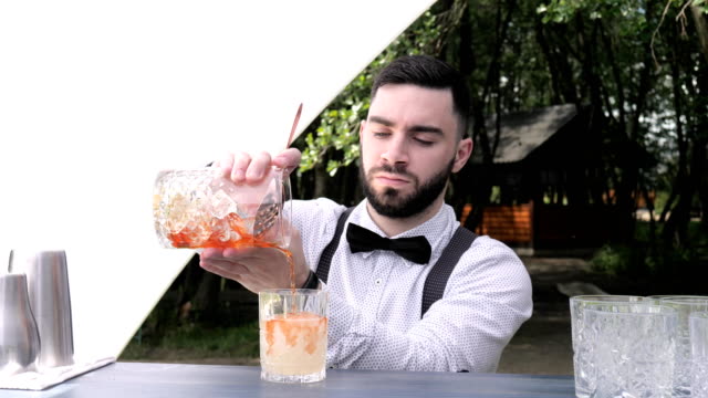 Barkeeper-gießt-Glas-in-vorbereiteten-Weinglas-mit-Likör,-bar-Arbeiter-Vorbereitung-cocktail-mischen